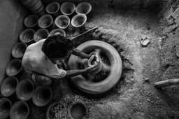 Hands shaping clay on a potter's wheel