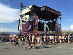 Large concert crowd facing a lit stage